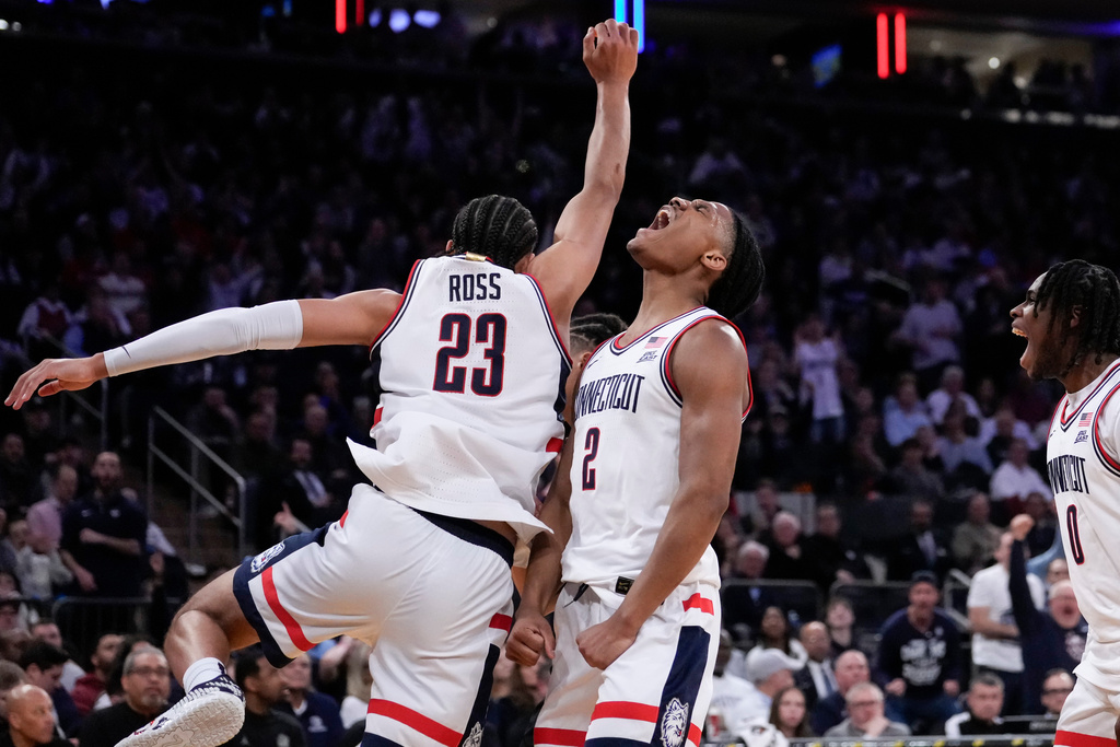 UConn guard Silas Demary Jr. (2) reacts after UConn forward Jayden Ross (23) dunked during the first half of an NCAA college basketball game against Georgetown in the semifinals of the Big East tournament, Friday, March 13, 2026, in New York. (AP Photo/Yuki Iwamura)