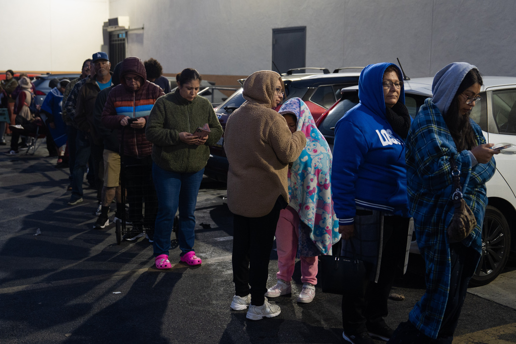 People wait in line to buy masa, a dough used to make tamales, outside Amapola Market in Downey, Calif., early Tuesday morning, Dec. 23, 2025. (AP Photo/Jae C. Hong)