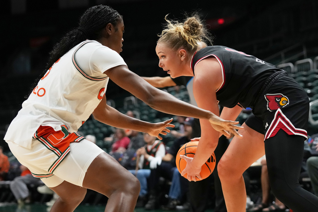 Louisville forward Laura Ziegler, right, controls the ball as Miami forward Soma Okolo, left, defends during the first half of an NCAA college basketball game, Thursday, Jan. 8, 2026, in Coral Gables, Fla. (AP Photo/Lynne Sladky)