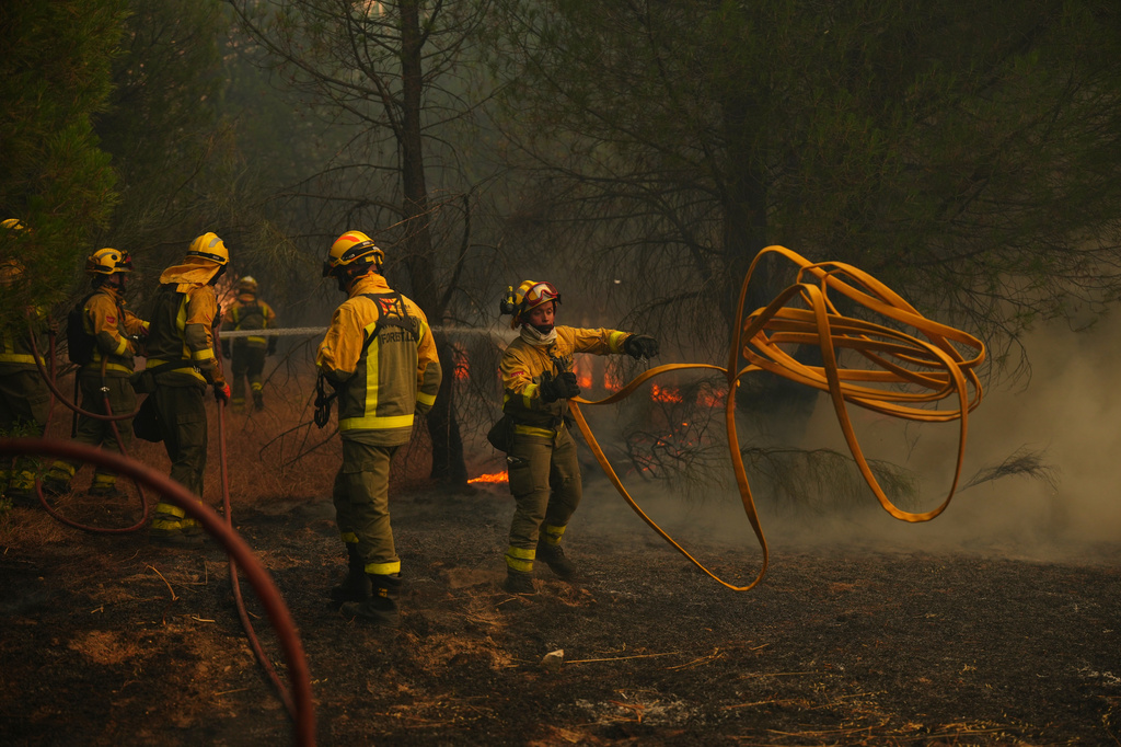 Firefighters battle a wildfire in San Martin de Valdeiglesias, west of Madrid, Spain, Sunday, July 26, 2026. (AP Photo/Manu Fernandez)