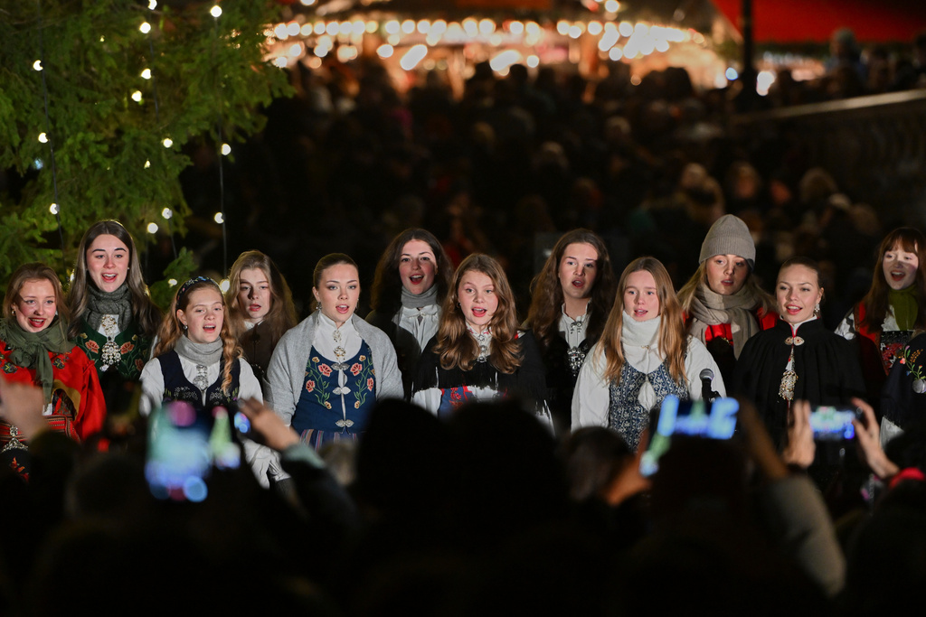 The traditional lighting up ceremony starts, with a choir singing carols, for the annual Norwegian gifted Christmas tree in Trafalgar Square, in London, England, Thursday, Dec. 4, 2025. (AP Photo/Thomas Krych)