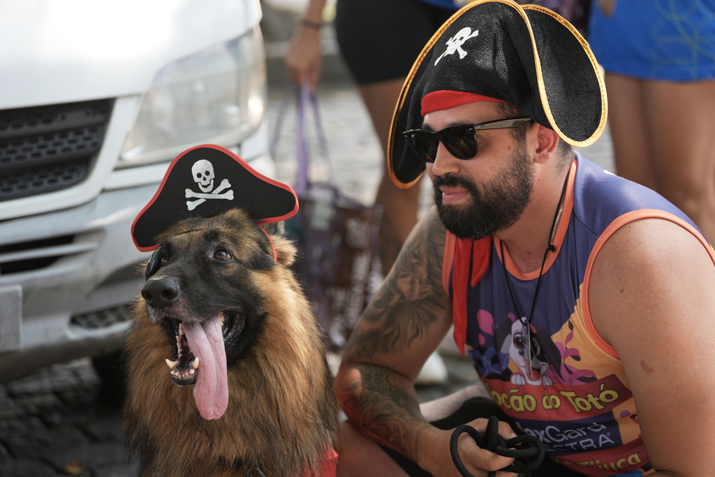 A dog and its owner wear pirate costume during the "Blocao" Carnival dog parade in Rio de Janeiro, Saturday, Feb. 14, 2026. (AP Photo/Silvia Izquierdo)