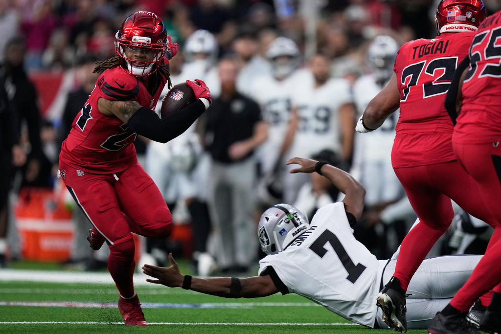 Houston Texans cornerback Derek Stingley Jr., left, returns an interception thrown by Las Vegas Raiders quarterback Geno Smith (7) for a touchdown during the first half of an NFL football game, Sunday, Dec. 21, 2025, in Houston. (AP Photo/Eric Christian Smith)
