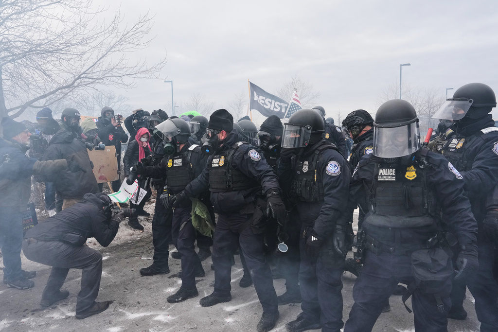 Federal immigration officers confront protesters outside Bishop Henry Whipple Federal Building, Thursday, Jan. 15, 2026, in Minneapolis. (AP Photo/Adam Gray)