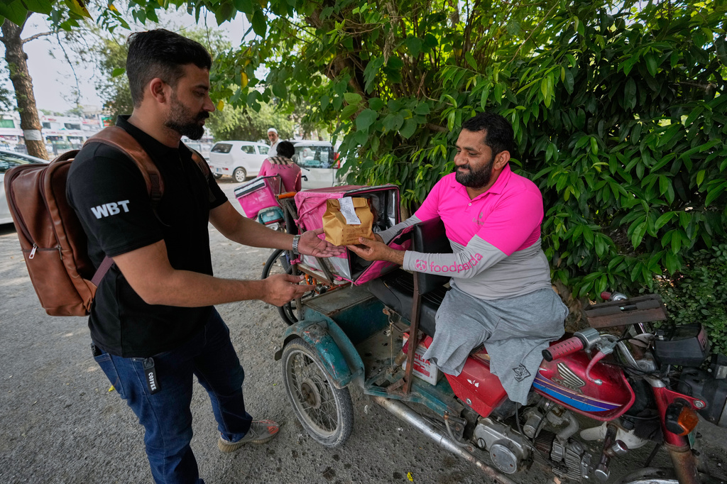 Hamza Ali, 28, who lost both legs in a road accident, delivers a meal order in Islamabad, Pakistan, Friday, July 17, 2026. (AP Photo/Anjum Naveed)
