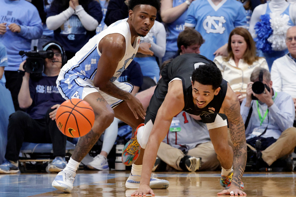 North Carolina guard Jaydon Young, left, and Virginia Tech guard Jailen Bedford, right, go after the ball during the first half of an NCAA college basketball game Saturday, Feb. 28, 2026, in Chapel Hill, N.C. (AP Photo/Chris Seward)