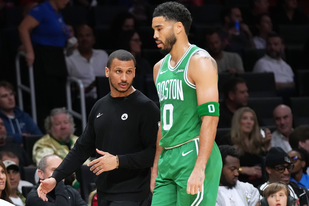 Boston Celtics head coach Joe Mazzulla, left talks with forward Jayson Tatum (0) during the first half of an NBA basketball game against the Miami Heat, Wednesday, April 1, 2026, in Miami. (AP Photo/Lynne Sladky)