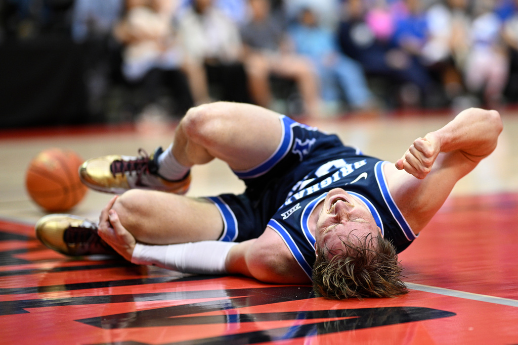 BYU guard Dawson Baker lies on the court after getting injured while driving to the basket during the second half of an NCAA college basketball game against Miami, Thursday, Nov. 27, 2025, in Kissimmee, Fla. (AP Photo/Phelan M. Ebenhack)