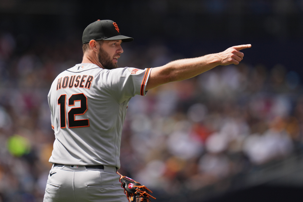San Francisco Giants starting pitcher Adrian Houser points towards second baseman Luis Arraez after getting the out on San Diego Padres' Jackson Merrill to end the third inning of a baseball game Wednesday, April 1, 2026, in San Diego. (AP Photo/Gregory Bull)