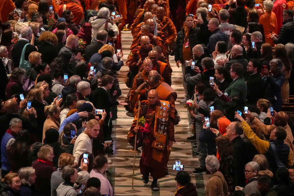 Monk Bhikkhu Pannakara, front, and his fellow Buddhist monks leave after an event at Washington National Cathedral to mark their Walk For Peace, Tuesday, Feb. 10, 2026, in Washington. (AP Photo/Mark Schiefelbein)