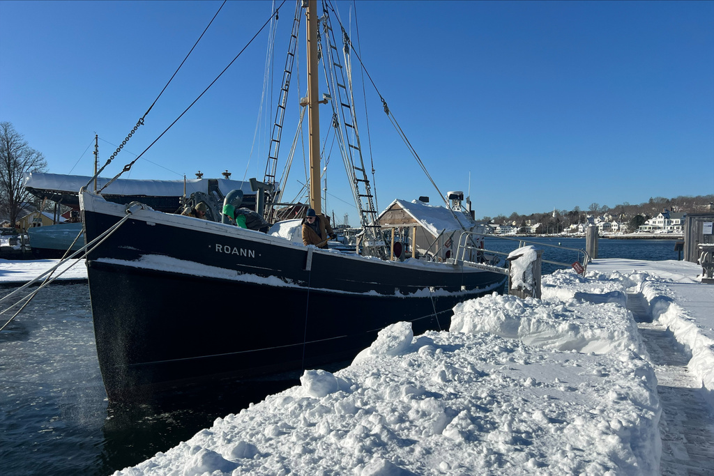 Workers carefully shovel away snow from the Roann at the Mystic Seaport Museum in Mystic, Conn., Tuesday, Feb. 24, 2026, following a snowstorm. (Shannon McKenzie/Mystic Seaport Museum via AP)