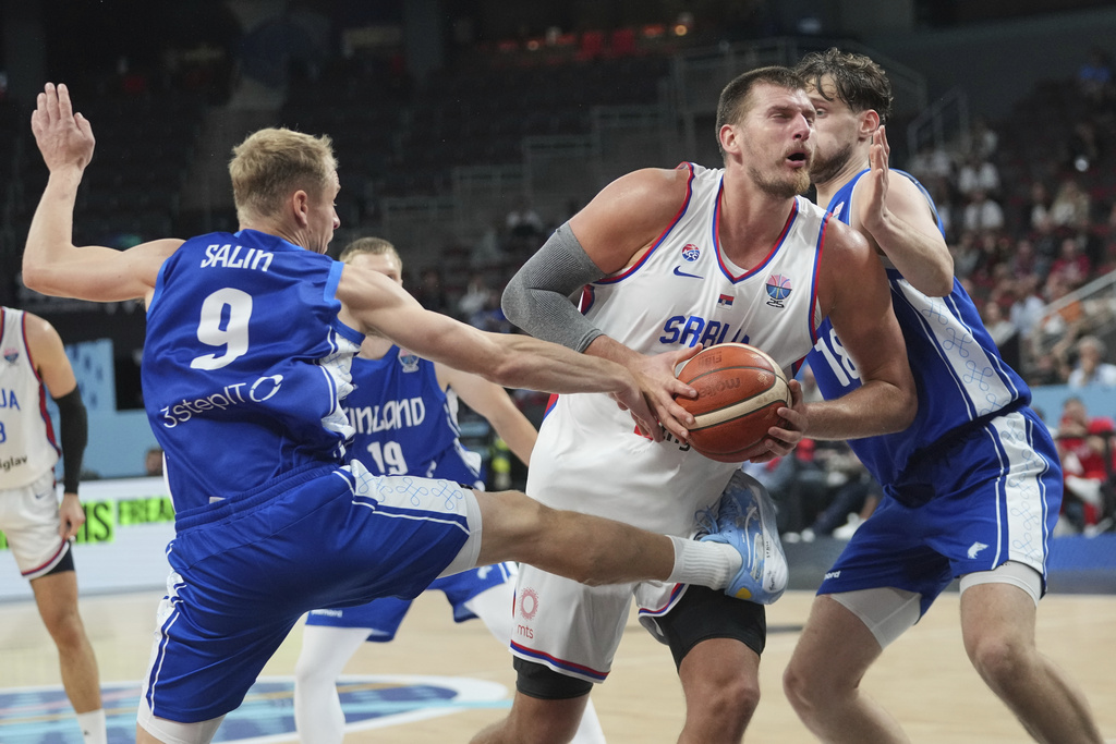 Serbia's Nikola Jokic drives between Finland's Sasu Salin, left, and Finland's Mikael Jantunen during the Eurobasket, European Basketball Championship round of 16 match between Serbia and Finland at the Riga Arena in Riga, Latvia, Saturday, Sept. 6, 2025. (AP Photo/Sergei Grits)