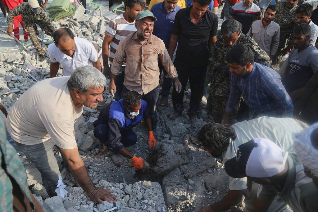 FILE - Rescue workers and residents search through the rubble in the aftermath of a strike on a girls' elementary school in Minab, Iran, Feb. 28, 2026. (Abbas Zakeri/Mehr News Agency via AP, file)