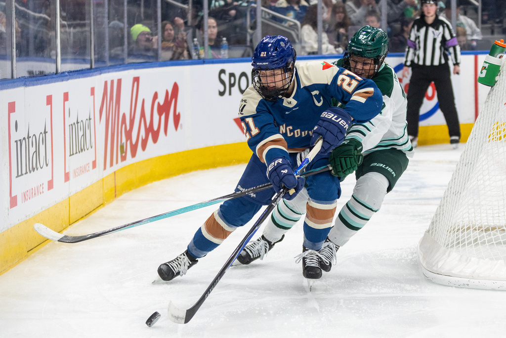 Boston Fleet's Shay Maloney (27) and Vancouver Goldeneyes' Ashton Bell (21) battle for the puck during second period PWHL hockey action in Edmonton on Tuesday, April 7, 2026. (Jason Franson/The Canadian Press via AP)