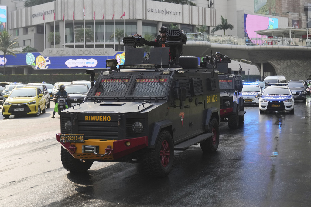 Officers of Indonesian National Police's paramilitary unit Mobile Brigade, man their position on armored vehicles as they patrol a street following days of violent protests against lavish allowances given to parliament members, at the main business district in Jakarta, Indonesia, Sunday, Aug. 31, 2025. (AP Photo/Dita Alangkara)