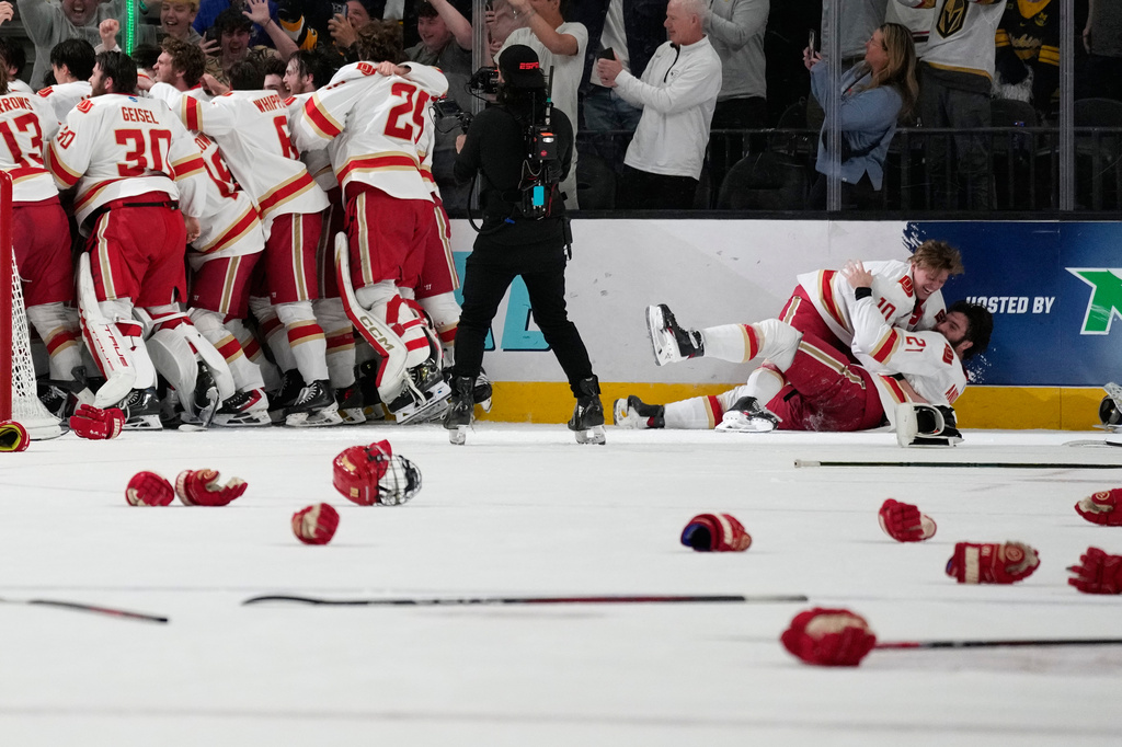 Denver players celebrate after defeating Wisconsin in the championship game at the NCAA Frozen Four men's college hockey tournament Saturday, April 11, 2026, in Las Vegas. (AP Photo/John Locher)