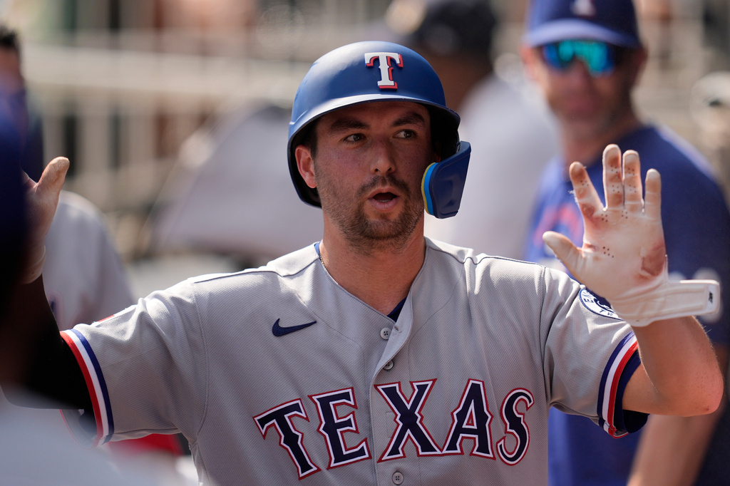 Texas Rangers catcher Kyle Higashioka (11) celebrates scoring off the bat of Wyatt Langford in the third inning of a baseball game against the Atlanta Braves, Saturday, July 18, 2026, in Atlanta. (AP Photo/Mike Stewart)
