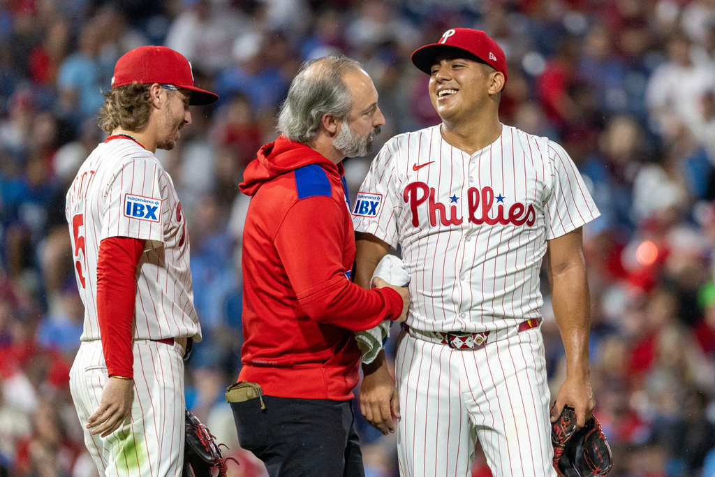 Philadelphia Phillies starting pitcher Ranger Suarez, right, is examined by a trainer before leaving the game after being hit by a ball in the fifth inning of a baseball game against the Minnesota Twins, Saturday, Sept. 27, 2025, in Philadelphia. (AP Photo/Laurence Kesterson)