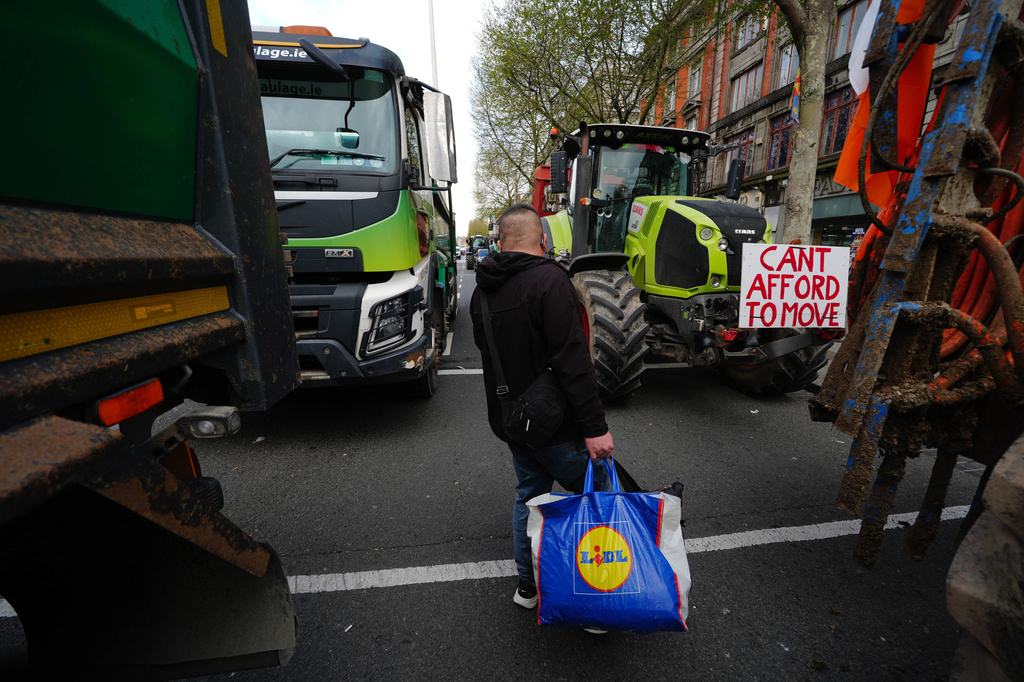 A man walks in between vehicles parked on O'Connell Street on the second day of a national fuel protest against rising fuel prices, in Dublin, Ireland, Wednesday April 8, 2026. (Brian Lawless/PA via AP)