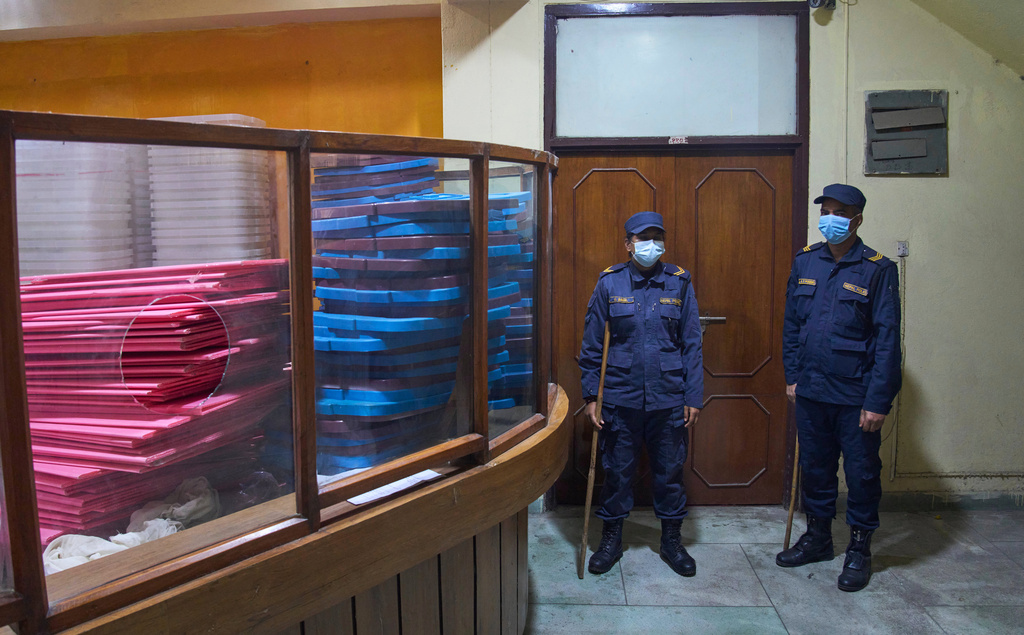 Police stand guard at the door as vote counting takes place, at a counting center for the parliamentary election in Lalitpur, Nepal, Sunday, March 8, 2026. (AP Photo/Niranjan Shrestha)