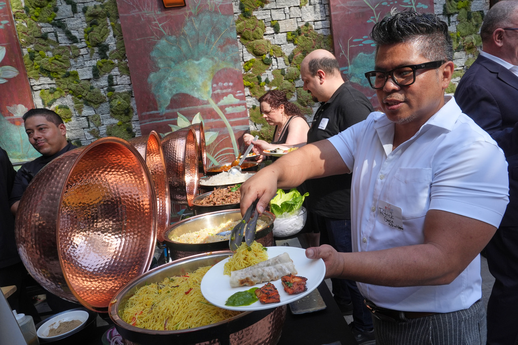 Patrick Garcia samples an array of Asian dishes during the South Beach Wine and Food Festival Friday, Feb. 20, 2026, in Miami Beach, Fla. (AP Photo/Marta Lavandier)