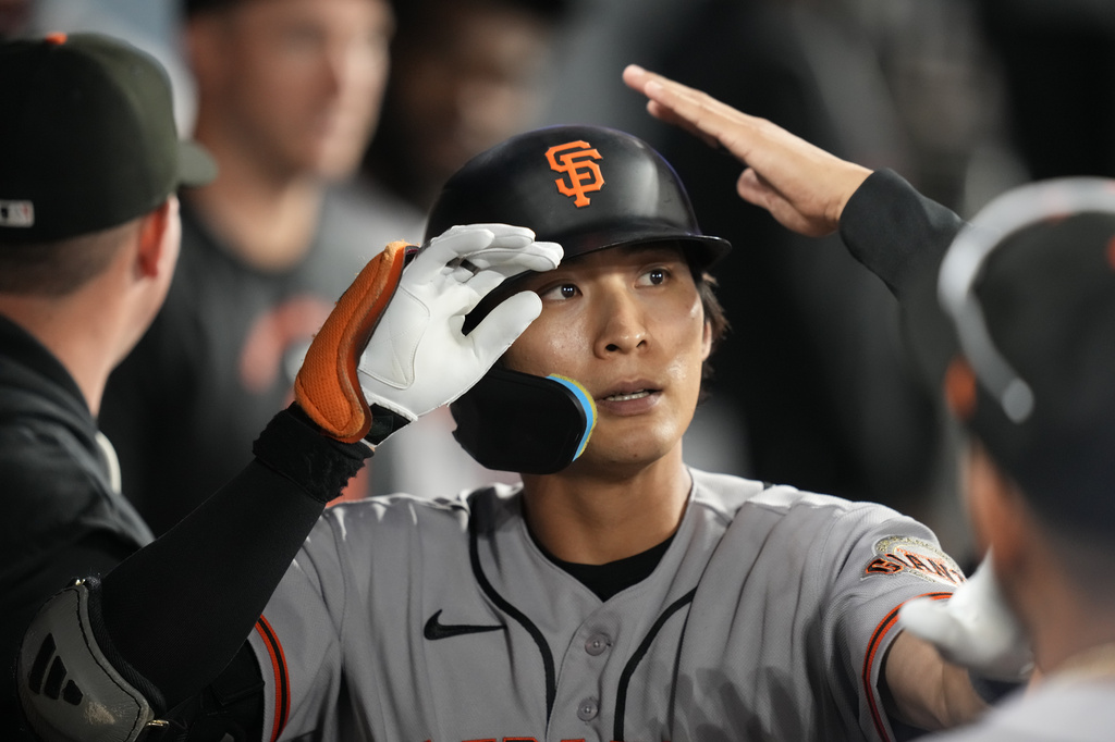 San Francisco Giants' Jung Hoo Lee is congratulated by teammates in the dugout after hitting a solo home run during the second inning of a baseball game against the Los Angeles Dodgers, Friday, Sept. 18, 2026, in Los Angeles. (AP Photo/Mark J. Terrill)