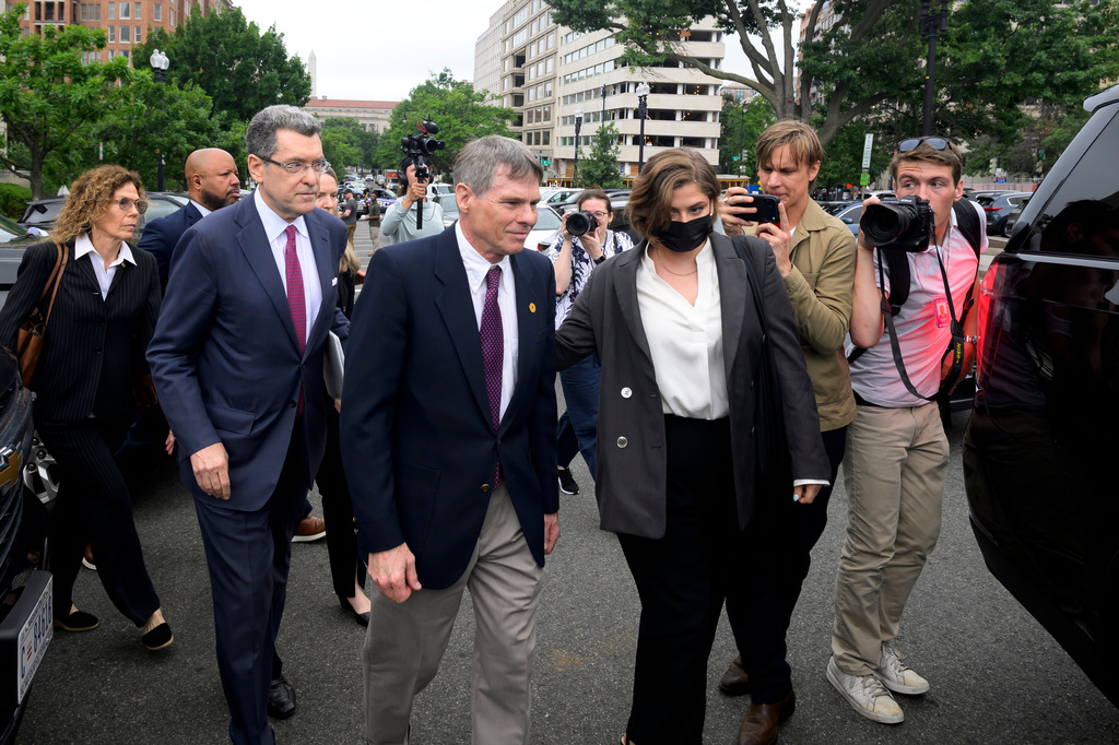 Former Olympic canoeist David Hearn, center, and his attorney Norman Eisen, left, walk to a car following a court appearance, where he pleaded not guilty to allegedly damaging the Lincoln Memorial Reflecting Pool, Thursday, July 9, 2026, in Washington. (AP Photo/Rod Lamkey, Jr.)