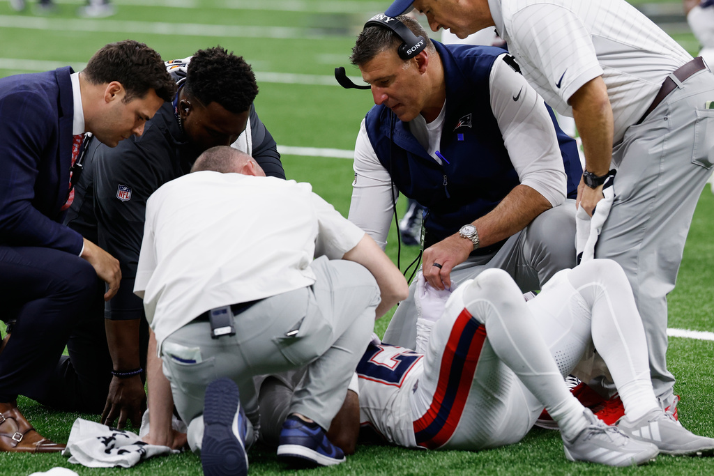 New England Patriots head coach Mike Vrabel, second from right, checks on cornerback Marcus Jones after an injury during the second half of an NFL football game against the New Orleans Saints, Sunday, Oct. 12, 2025, in New Orleans. (AP Photo/Butch Dill)