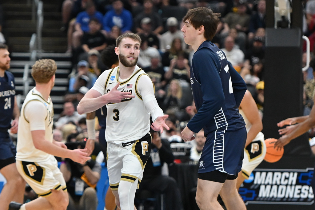 Purdue's Braden Smith (3) celebrates after making a 3-point basket as Queens University's Carson Schwieger, right, watches during the second half in the first round of the NCAA college basketball tournament, Friday, March 20, 2026, in St. Louis. (AP Photo/Ali Overstreet)