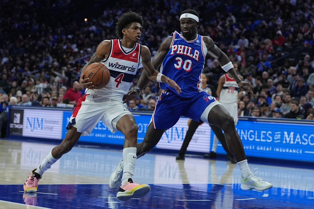 Washington Wizards' AJ Johnson (4) tries to get a shot past during the first half of an NBA basketball game Wednesday, Jan. 7, 2026, in Philadelphia. (AP Photo/Matt Rourke)