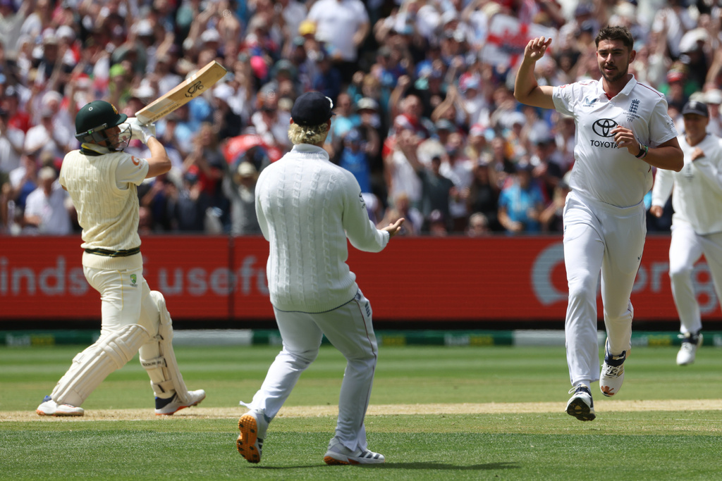 England's Josh Tongue, right, celebrates the wicket of Australia's Marnus Labuschagne, left, during their Ashes cricket test match in Melbourne, Friday, Dec. 26, 2025. (AP Photo/Hamish Blair)