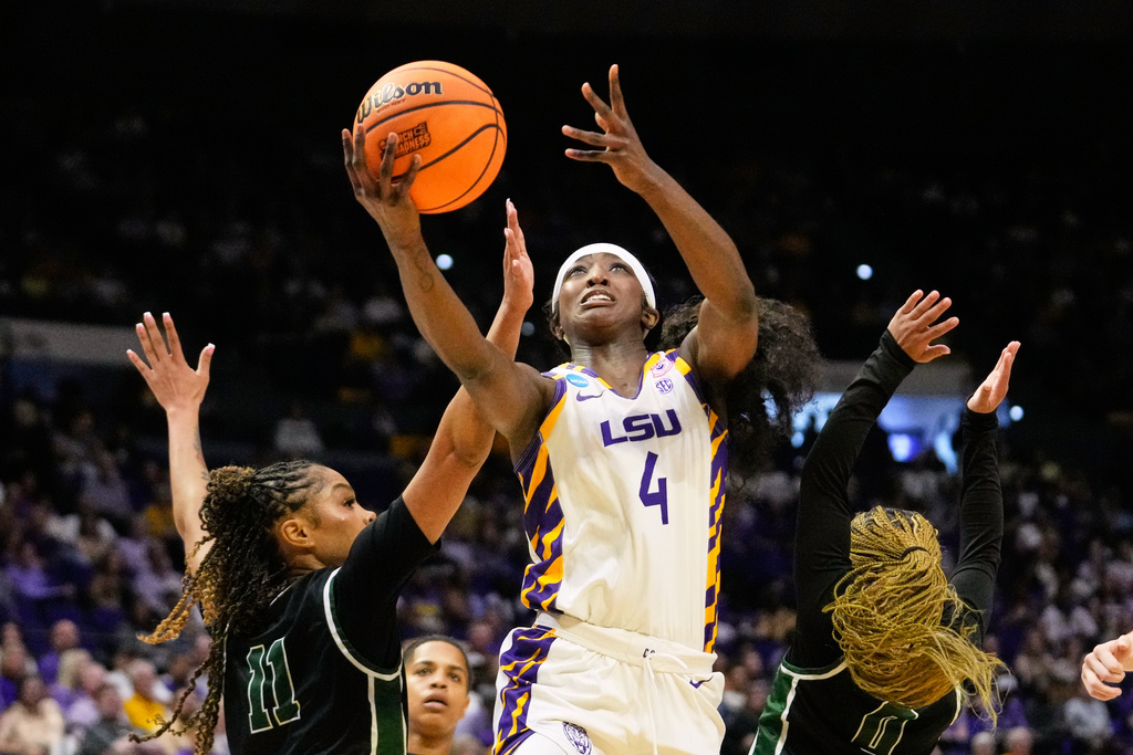 LSU guard Flau'jae Johnson (4) goes to the basket between Jacksonville guard Bailey Burns (11) and guard Aniah Smith (0) during the first half in the first round of the NCAA college basketball tournament, Friday, March 20, 2026, in Baton Rouge, La. (AP Photo/Gerald Herbert)