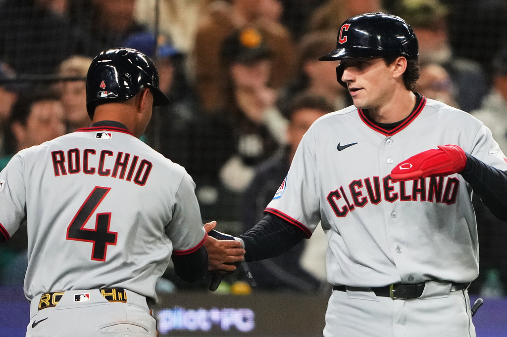 Cleveland Guardians' Brayan Rocchio (4) greets Chase DeLauter, right, after they scored on a two-run double by José Ramirez against the Seattle Mariners during the seventh inning of an opening-day baseball game, Thursday, March 26, 2026, in Seattle. (AP Photo/Lindsey Wasson)