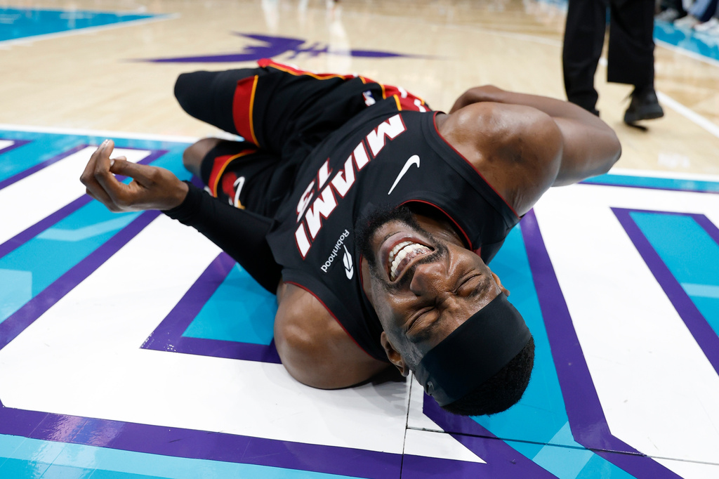 Miami Heat center Bam Adebayo (13) lies on the court during the first half of an NBA play-in tournament basketball game against the Charlotte Hornets in Charlotte, N.C., Tuesday, April 14, 2026. (AP Photo/Nell Redmond)