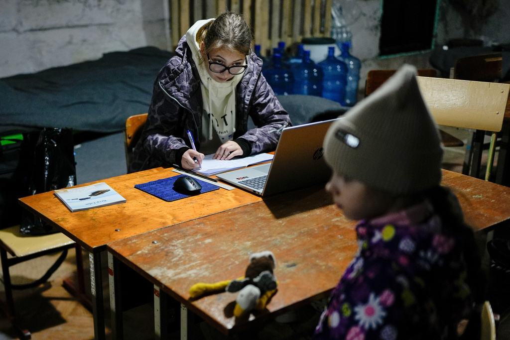 Sofia Sisa, 17, does homework in an underground shelter during an air raid alarm, Thursday, Oct. 16, 2025, in Shostka, Ukraine. (AP Photo/Julia Demaree Nikhinson)