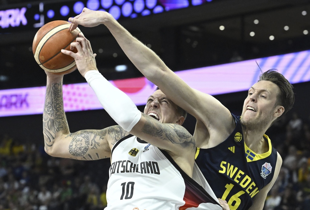 Germany's Daniel Theis, left, and Sweden's Nicholas Spires during Eurobasket, European Basketball Championship group B match between Germany and Sweden in Tampere, Finland, Friday, Aug. 29, 2025. (Heikki Saukkomaa/Lehtikuva via AP)