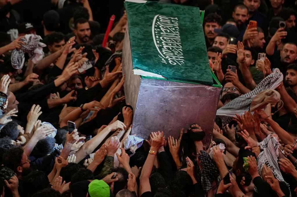 The coffin of the late Iranian Supreme Leader Ayatollah Ali Khamenei is carried through a crowd as mourners jostle to reach and touch it outside the Imam Hussein Shrine in Karbala, Iraq, early Thursday, July 9, 2026. (AP Photo/Khalil Hamra)