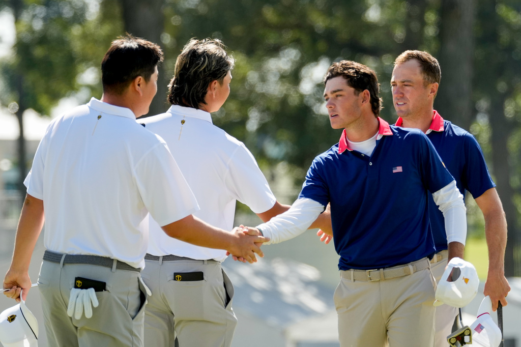 USA teams' Jackson Koivun and Justin Thomas, right, greet International teams' Sungjae Im, of South Korea, left, and Min Woo Lee, of Australia, after their Presidents Cup golf tournament third round four-ball match at Medinah Country Club, Saturday, Sept. 26, 2026, in Medinah, Ill. (AP Photo/Chris Carlson)