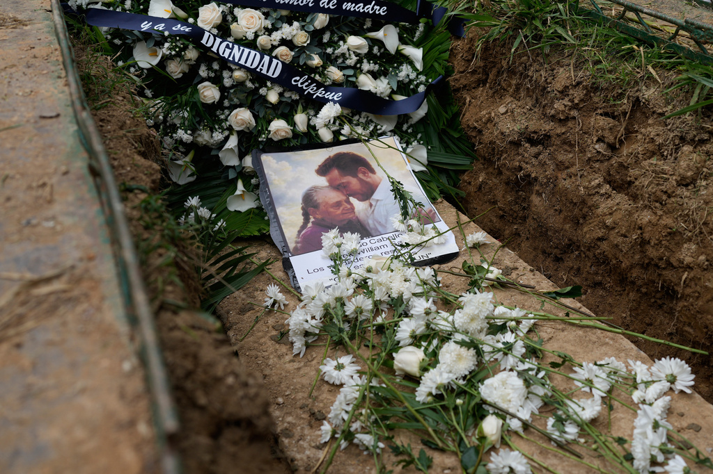 FILE - A photo of Carmen Navas and son Victor Hugo Quero, who authorities said died in custody following his arrest about a year earlier, lies on the coffin that contains Navas' remains during her burial service in Caracas, Venezuela, May 19, 2026. (AP Photo/Ariana Cubillos, File)