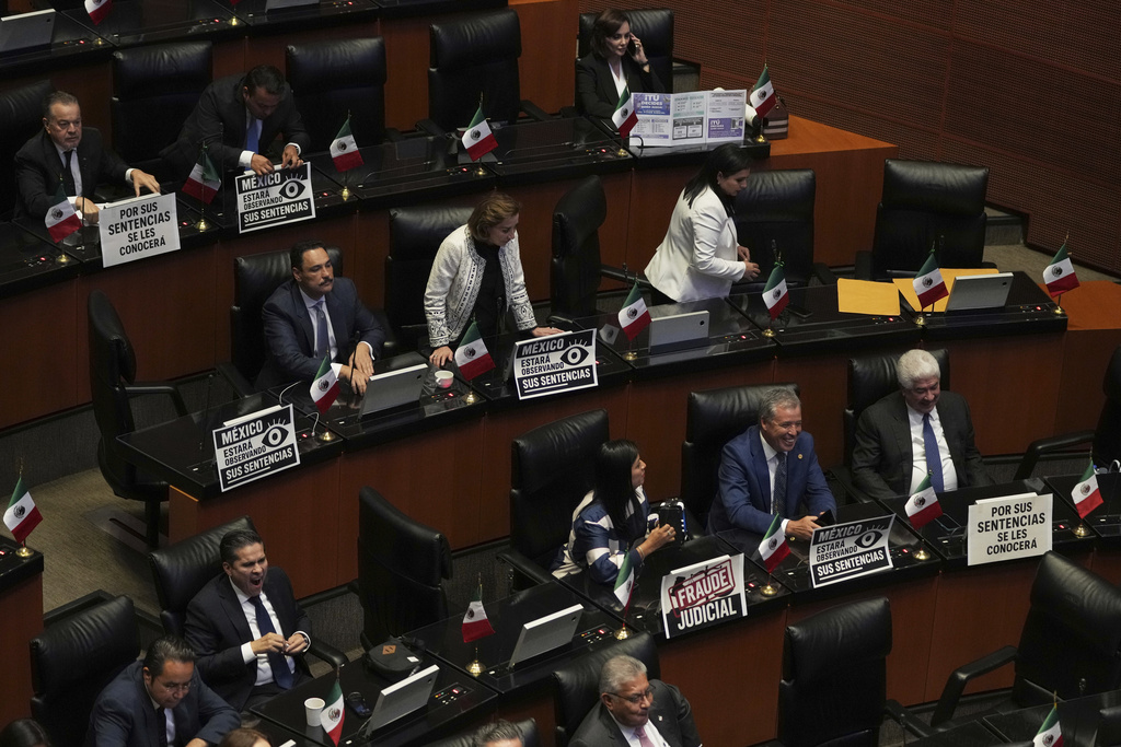 Opposition senators hold up signs protesting the government's judicial reform, ahead of the Supreme Court's swearing-in ceremony, at the Senate in Mexico City, Monday, Sept. 1, 2025. (AP Photo/Eduardo Verdugo)