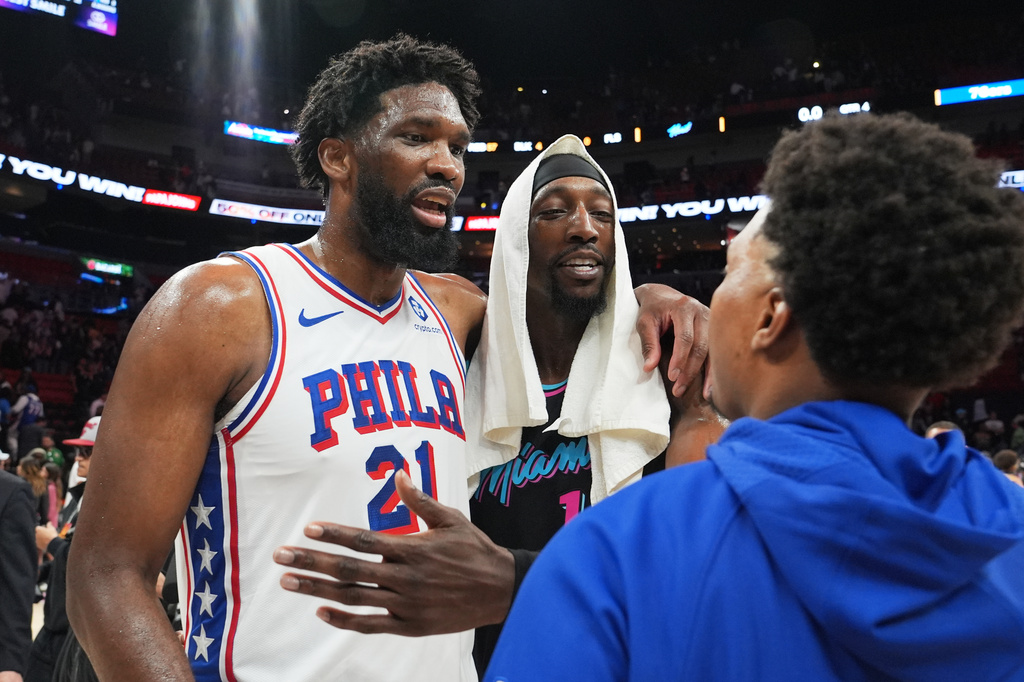Philadelphia 76ers center Joel Embiid, left, and Miami Heat center Bam Adebayo, center, talk with Philadelphia 76ers guard Kyle Lowry, right, after an NBA basketball game, Monday, March 30, 2026, in Miami. (AP Photo/Lynne Sladky)