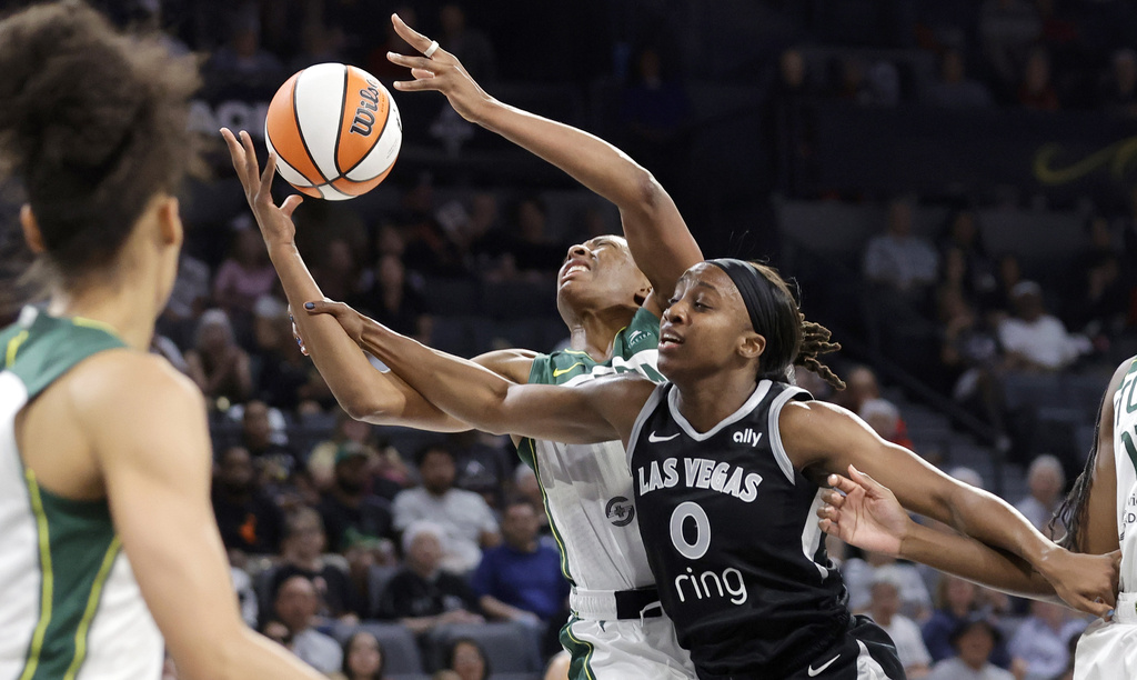 Seattle Storm forward Nneka Ogwumike, center left, and Las Vegas Aces guard Jackie Young (0) fight for a rebound during the first half of a WNBA basketball game Friday, Aug. 8, 2025, in Las Vegas. (Steve Marcus/Las Vegas Sun via AP)