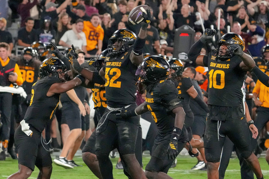 Surrounded by teammates Arizona State Sun Devils defensive lineman Prince Dorbah (32) celebrates his strip sack from TCU Horned Frogs quarterback Josh Hoover (10) during the second half of an NCAA college football game Friday, Sept. 26, 2025, in Tempe, Ariz. (AP Photo/Darryl Webb)
