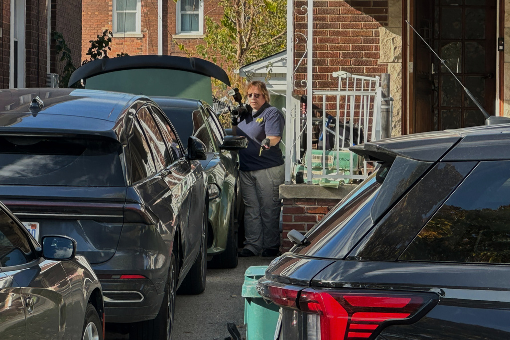 FBI agents gather outside a home in a Dearborn, Mich., neighborhood on Friday, Oct. 31, 2025. (AP Photo/Mike Householder)