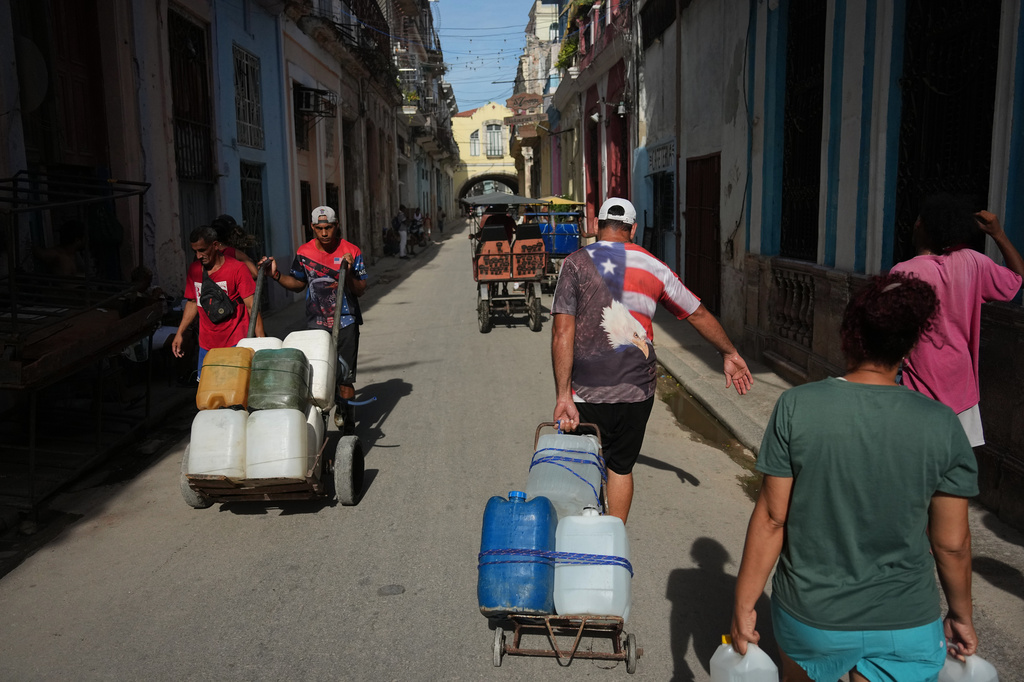 People carry water during a power outage in Havana, Cuba, Monday, Aug. 3, 2026. (AP Photo/Ramon Espinosa)