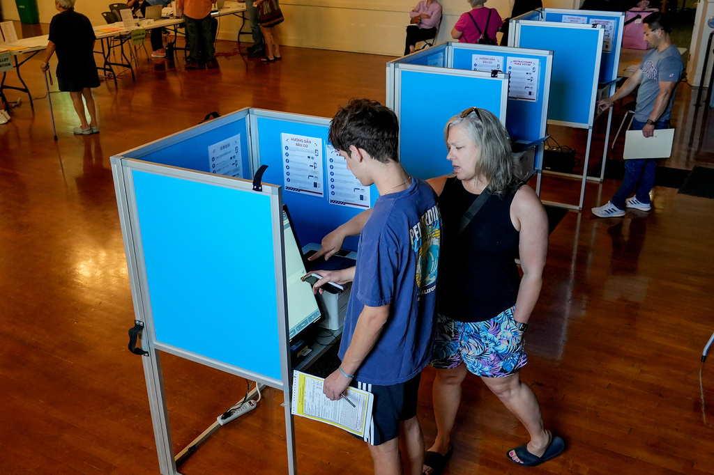 Colton Kapicka, 18, gets some help from his mother, Kelly Kapicka as he marks his ballot while voting in his first election, in Sacramento, Calif., Tuesday, June 2, 2026. (AP Photo/Rich Pedroncelli)