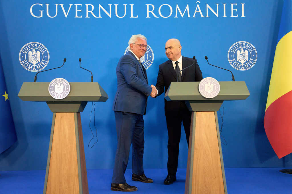 Romanian Prime Minister Ilie Bolojan, right, shakes hands with Germany's Rheinmetall AG CEO Armin Pappergerafter a joint press statement in Bucharest, Romania, Monday, Nov. 3, 2025, following the signing of a partnership to build an ammunition powder factory. (AP Photo/Vadim Ghirda)