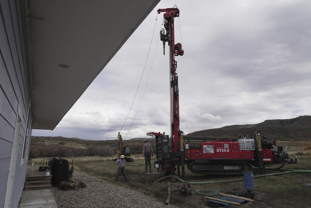 The Cooper family prepares to drill a hole for a geothermal heat pump installation Thursday, Oct. 9, 2025, in Hamilton, Colo. (AP Photo/Brittany Peterson)