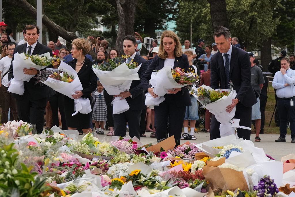 New South Wales Premier Chris Minns, right, and Kellie Sloane, leader of the opposition, the New South Wales Liberal Party, lay wreaths at a tribute for shooting victims outside the Bondi Pavilion at Sydney's Bondi Beach, Monday, Dec. 15, 2025, a day after a shooting. (AP Photo/Mark Baker)