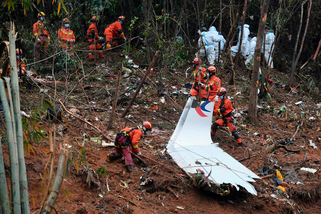 FILE - In this photo released by Xinhua News Agency, search and rescue workers search through debris at the China Eastern flight crash site in Tengxian County in southern China's Guangxi Zhuang Autonomous Region on March 24, 2022. (Lu Boan/Xinhua via AP, File)